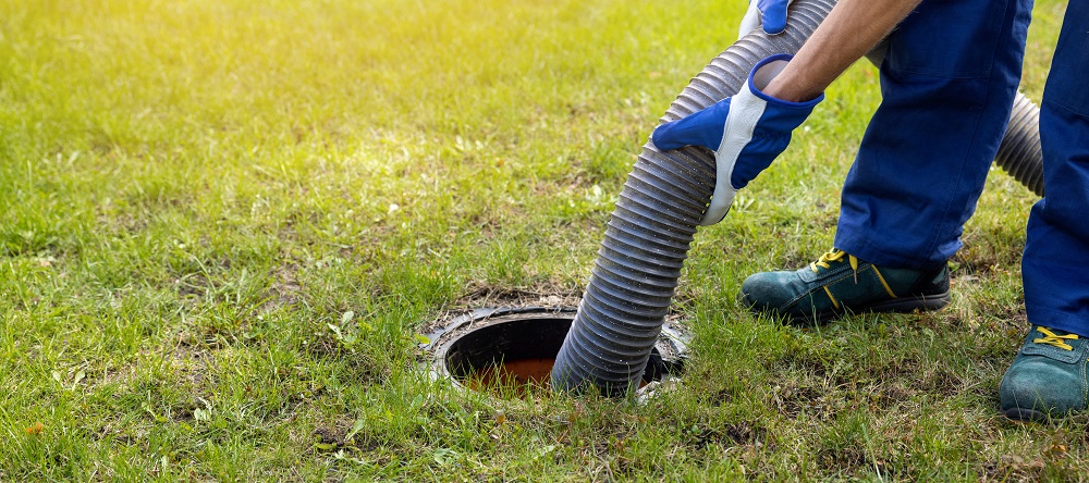 man pumping out house septic tank. drain and sewage cleaning ser